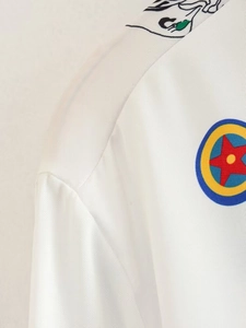 Détails de couture d'épaule et badge étoile coloré sur une chemise blanche chic