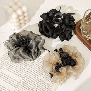 Detailed view of ostrich feather hair claws in black, silver gray, and champagne gold