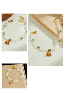 Detail of beaded bracelet with turquoise stones and golden cherry pendant charm