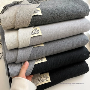 Detail of multi-color twill cashmere-like scarves with elegant woven brand labels