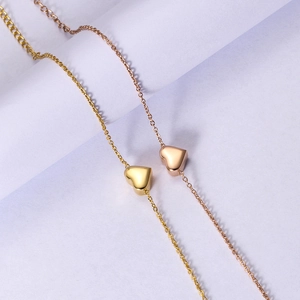 Detail shot of heart-shaped pendants in gold and rose gold on elegant cross chains