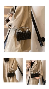 Black evening clutch with crinkle texture and silver lion-head handle detail