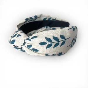Detailed view of linen texture and green leaf print on the knotted headband