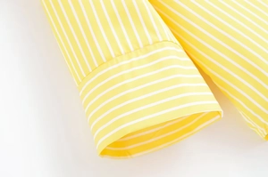 Macro detail of high-quality yellow and white striped fabric cuff with precise stitching