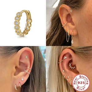 Close-up of gold S925 sterling silver hoop earrings with pavé cubic zirconia on model ear