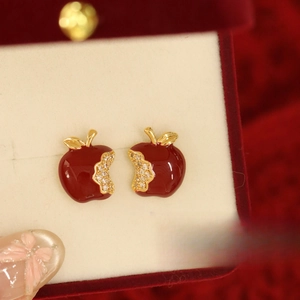 Close-up of red enamel apple stud earrings with gold edges and white zircon accents
