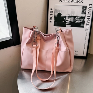 Borsa tote rosa in pelle PU capiente con doppi spallacci su un tavolo in metallo