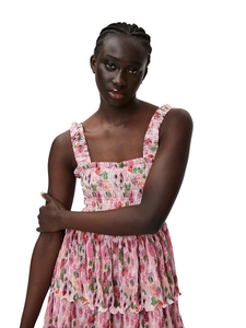Detail of pink floral dress featuring smocked bodice and tiered ruffle hemline