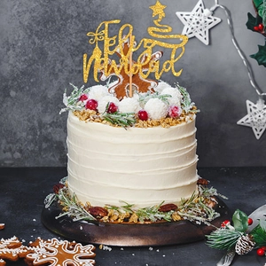 Close-up of golden glitter Feliz Navidad cake topper with stars and Christmas trees