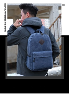 Blue canvas backpack featuring a classic lash tab and front zipper pocket on model back