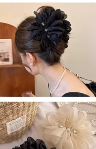 Detail einer eleganten Chiffon-Blumen-Haarklammer mit Strass und weichen Schichten