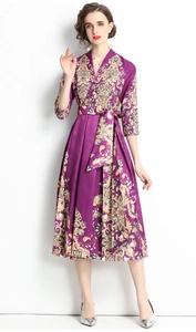 Detail of elegant V-neck purple dress with silk-like paisley patterns and waist tie