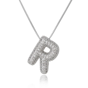 Macro shot of silver letter R pendant with sparkling zircons on a box chain