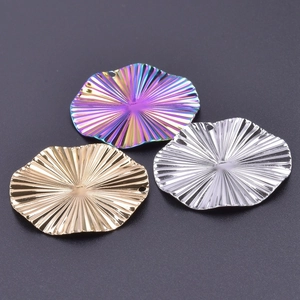 Detail of flower shaped steel pendants with radial textures in gold silver and rainbow colors