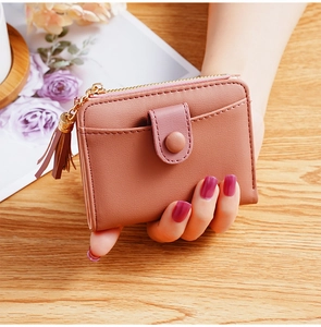 Close-up of pink PU leather mini wallet with tassel zipper and snap fastener detail