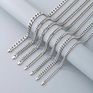 Macro shot of polished silver Cuban link necklaces in multiple thicknesses and layered waves