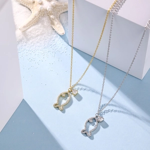 Detailed close-up of gold and silver fish pendants with sparkling cubic zirconia inlay
