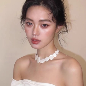 Close-up of minimalist white round shell necklace on model with pearl luster finish