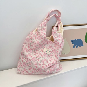 Close-up of pink floral shoulder tote bag with embossed bear texture and logo detail