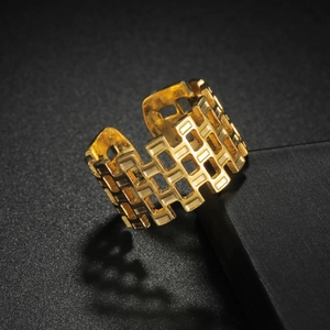 Gold plated stainless steel geometric hollow square grid ring on a black surface