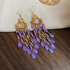 Macro shot of purple beaded tassel earrings with vintage golden metal detailing