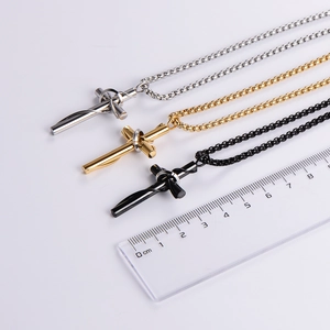 Three stainless steel cross necklaces in silver, gold, and black with measurement ruler