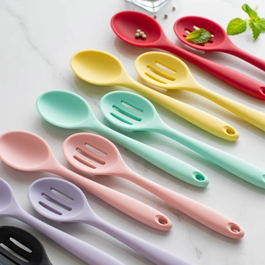 Bunte Silikonlöffel und Schaumlöffel Set auf einer weißen Marmoroberfläche