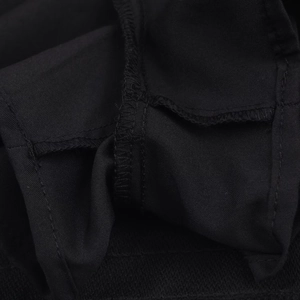 Detailed close-up of high-quality stitching and seam work on black ruffled skort fabric