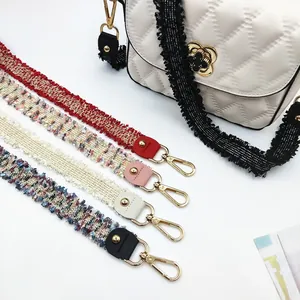 Detail of tweed purse straps with gold hooks in red, pink, cream and blue-grey colors