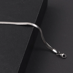 Macro shot of 4mm silver snake chain necklace with lobster clasp on black background