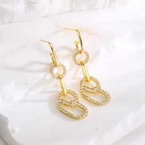 18K gold-plated geometric heart earrings with zircon stones on white stone background