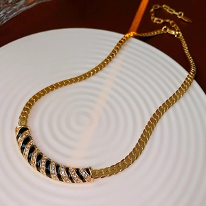 Dettaglio della collana vintage placcata in oro con smalto nero e cristalli scintillanti