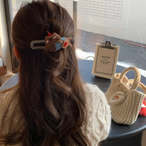 Close-up of cute plush puppy hair clip featuring brown and denim fabric for hair styling