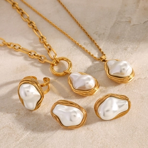 Baroque pearl jewelry set with textured gold necklace and earrings on stone background