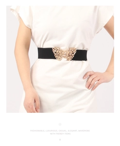 Close-up of elegant black elastic belt with a golden rhinestone butterfly buckle for dresses