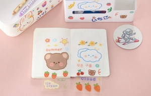 Flat lay of cute cartoon stationery including PVC stickers and a pink organizer tray