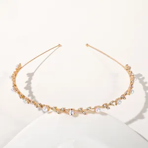 Detail of golden metal leaf headband with white pearls and sparkling rhinestones
