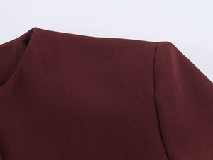 Close-up of burgundy tweed fabric texture and shoulder seam on a vintage crop blazer
