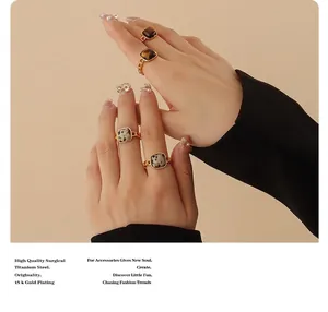 Detail of 18K gold plated titanium rings with tiger eye and marble stone on model hand