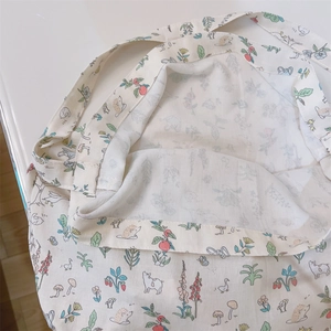 Close-up of cream floral cotton tote showing detailed hedgehog and duck print patterns
