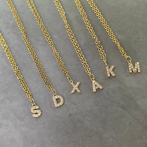Elegante gouden kettingen met micro-geplaveide kristallen letterhangers aan ketting