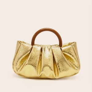 Close-up of golden crocodile texture cloud bag with stylish brown resin ring handle