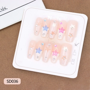 Handmade pink press-on nails with colorful stars and rhinestones on a white display card