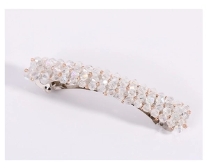 Gros plan d'une barrette en cristal étincelant avec base en métal argenté sur fond blanc