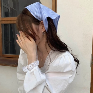 Detail of blue and white checkered cotton bandana with vintage aesthetic on model
