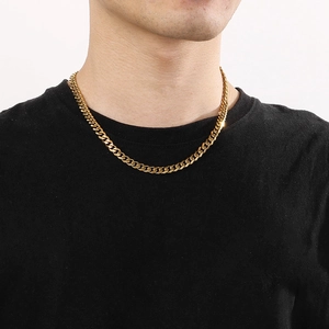 Detail of a men's gold Cuban link chain showing the shiny finish and fit on neck