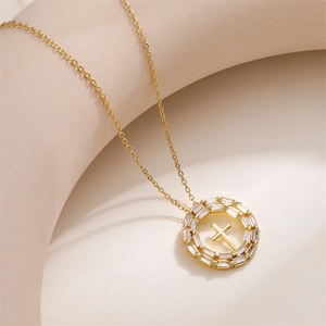 Détail d'un pendentif croix dorée avec double rangée de zircons de taille baguette