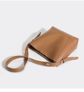 Detail view of the adjustable long shoulder strap on this stylish brown leather bucket bag