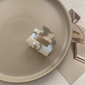 Dettaglio molletta per capelli quadrata effetto marmo perlato su vassoio in ceramica