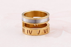 Detailed shot of gold dual-band ring featuring white shell inlay and Roman numeral motifs